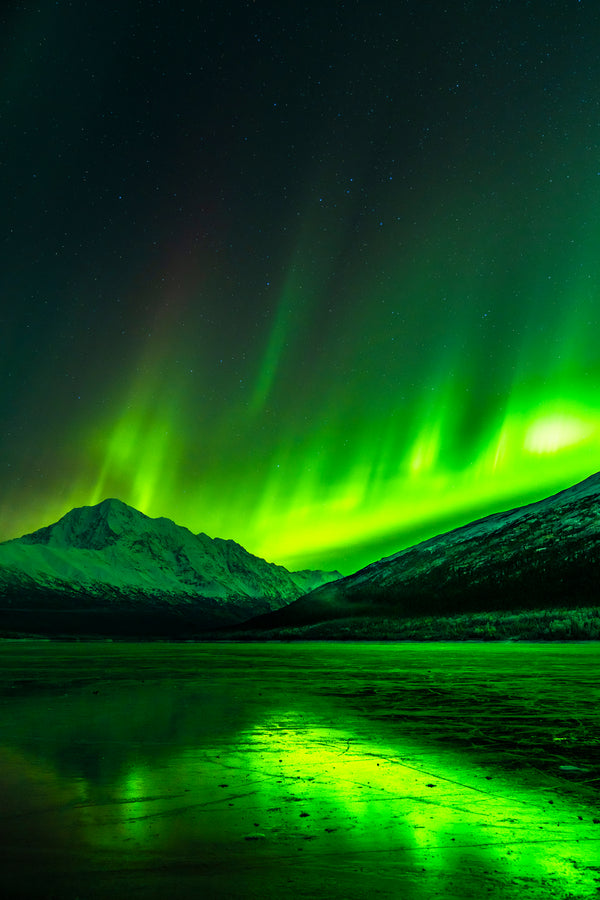 Aurora borealis reflected on frozen Eklutna Lake, Alaska